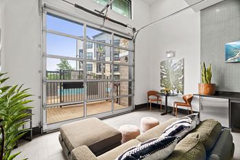 A modern living room with a large window and a view of a building outside.